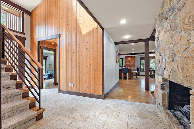 2500 Wahoo Ct, Morris, IL 60450 - entryway with stone tile floors, wood walls, stairs, a fireplace, and a high ceiling
