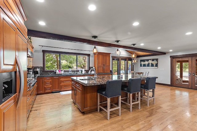 2500 Wahoo Ct, Morris, IL 60450 - kitchen with recessed lighting, brown cabinetry, a breakfast bar area, french doors, and a center island with sink