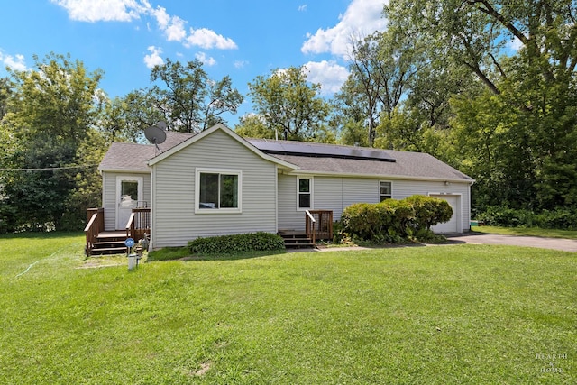 27405 N Roberts Ln, Island Lake, IL 60042 - rear view of house featuring solar panels, a garage, a yard, concrete driveway, and roof with shingles