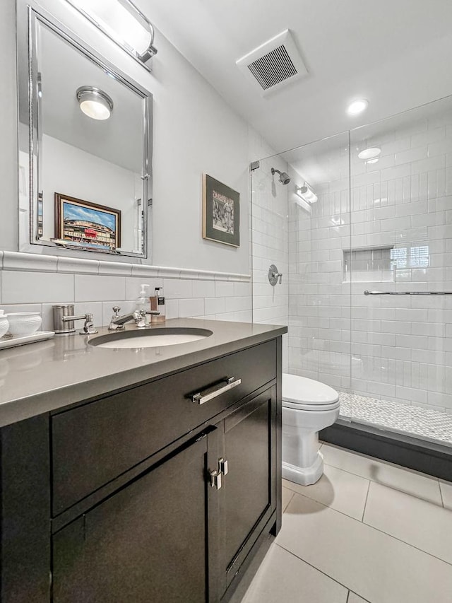 2123 N Bissell St, Chicago, IL 60614 - bathroom featuring vanity, a stall shower, toilet, tile patterned flooring, and tile walls