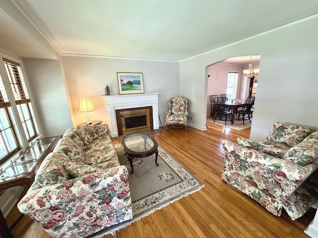 10043 S Artesian Ave, Chicago, IL 60655 - living room with wood finished floors, ornamental molding, arched walkways, a tile fireplace, and a chandelier
