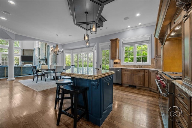 1088 Dunstan Rd, Geneva, IL 60134 - kitchen featuring appliances with stainless steel finishes, decorative columns, a center island, a breakfast bar, and brown cabinetry