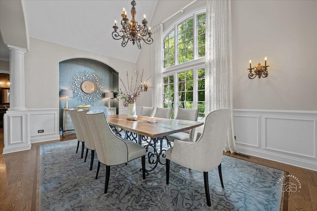 1088 Dunstan Rd, Geneva, IL 60134 - dining area featuring ornate columns, wainscoting, a decorative wall, wood finished floors, and a chandelier
