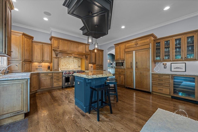 1088 Dunstan Rd, Geneva, IL 60134 - kitchen with wine cooler, built in appliances, brown cabinetry, arched walkways, and recessed lighting
