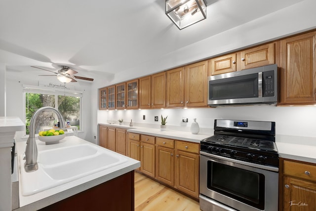 1910 Baldwin Way, Bolingbrook, IL 60490 - kitchen featuring appliances with stainless steel finishes, light countertops, light wood-style flooring, glass insert cabinets, and a ceiling fan