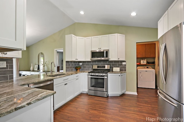 4008 W Lillian St, Mchenry, IL 60050 - kitchen featuring appliances with stainless steel finishes, washer / dryer, vaulted ceiling, tasteful backsplash, and white cabinets