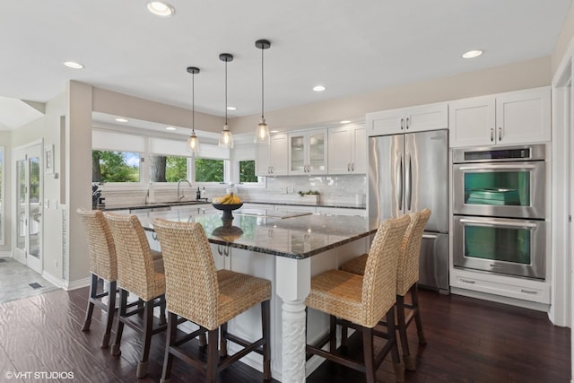 6N142 Riverside Dr, Saint Charles, IL 60175 - kitchen featuring stainless steel appliances, white cabinetry, glass insert cabinets, decorative backsplash, and a center island