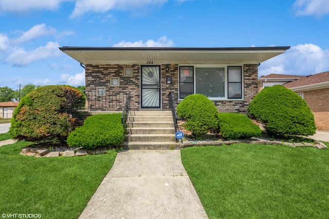 364 Hoxie Ave, Calumet City, IL 60409 - view of front of home with covered porch, a front lawn, and brick siding