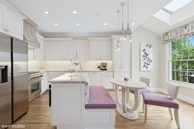 37 Harborside Way, Hawthorn Woods, IL 60047 - kitchen featuring stainless steel appliances, custom range hood, light wood finished floors, a skylight, and a center island