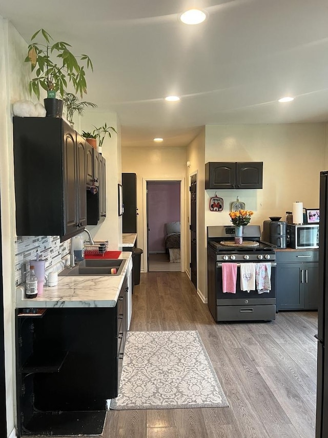 1901 Cora St, Crest Hill, IL 60403 - kitchen with appliances with stainless steel finishes, light countertops, light wood-style floors, recessed lighting, and tasteful backsplash