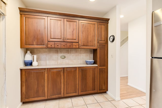 5400 S Hyde Park Blvd Unit 10C, Chicago, IL 60615 - kitchen featuring freestanding refrigerator, tasteful backsplash, light tile patterned floors, brown cabinetry, and recessed lighting