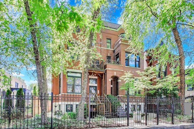 2031 W Evergreen Ave Unit 1W, Chicago, IL 60622 - victorian house with a fenced front yard, brick siding, and a balcony
