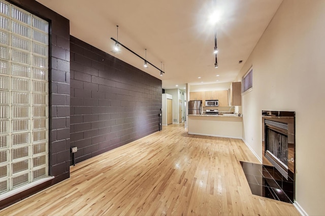 2031 W Evergreen Ave Unit 1W, Chicago, IL 60622 - unfurnished living room with light wood-style floors, a fireplace, and track lighting