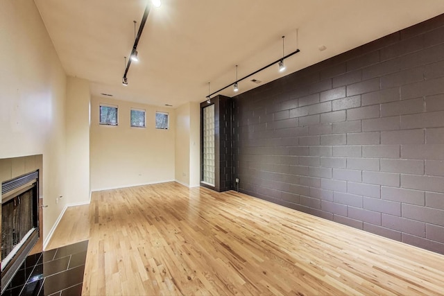 2031 W Evergreen Ave Unit 1W, Chicago, IL 60622 - unfurnished living room with rail lighting, wood finished floors, and a fireplace