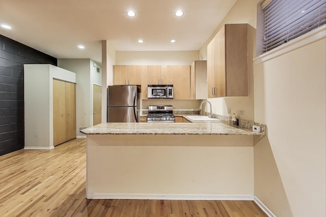 2031 W Evergreen Ave Unit 1W, Chicago, IL 60622 - kitchen featuring stainless steel appliances, a peninsula, light stone counters, light wood-style floors, and recessed lighting