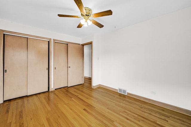 10021 Cook Ave, Oak Lawn, IL 60453 - unfurnished bedroom featuring two closets, light wood-style flooring, and a ceiling fan