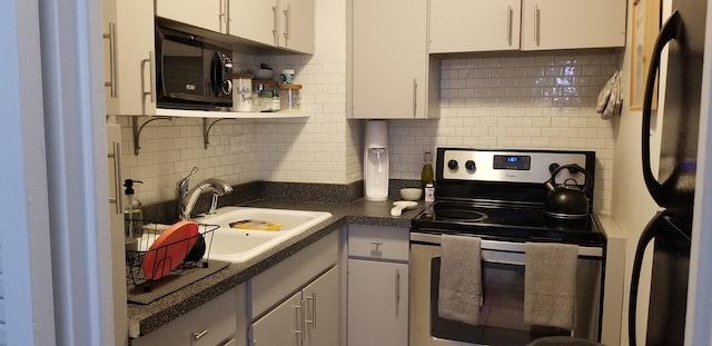 21 W Goethe St Unit 7C, Chicago, IL 60610 - kitchen with stainless steel range with electric cooktop, freestanding refrigerator, black microwave, a sink, and decorative backsplash