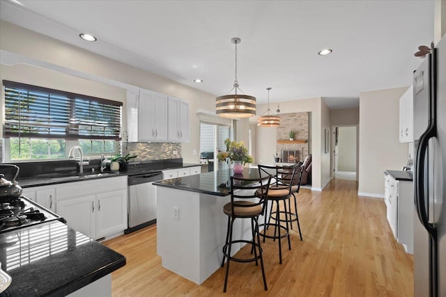 13613 Arborview Blvd, Plainfield, IL 60585 - kitchen featuring dishwasher, a breakfast bar area, a kitchen island, backsplash, and light wood-type flooring