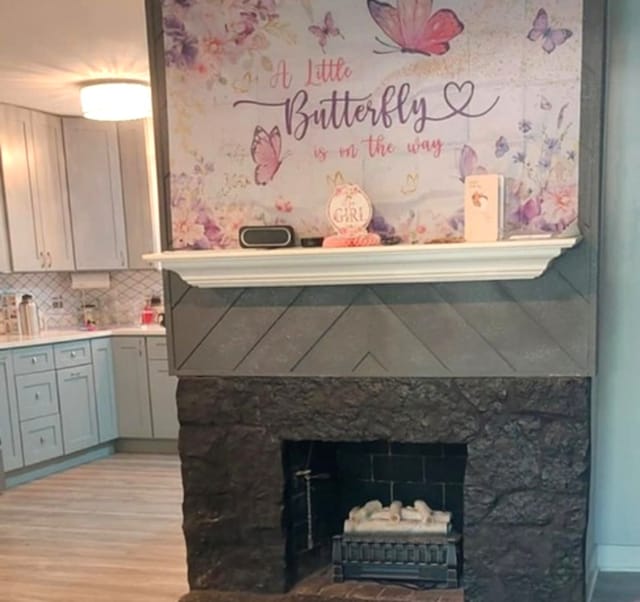 348 Niagara St, Park Forest, IL 60466 - detailed view of light wood-style floors, a large fireplace, light countertops, and decorative backsplash