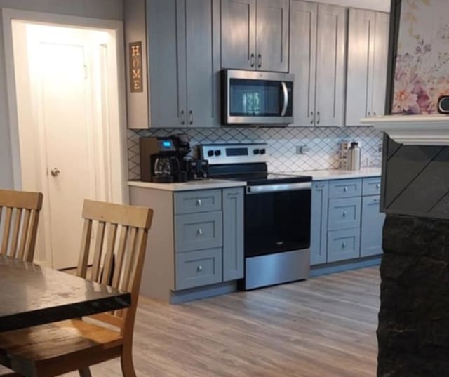348 Niagara St, Park Forest, IL 60466 - kitchen with stainless steel appliances, light wood-style floors, light countertops, and tasteful backsplash