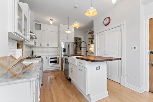 1128 W Wolfram St Unit 2, Chicago, IL 60657 - kitchen with wooden counters, tasteful backsplash, stainless steel appliances, light wood finished floors, and white cabinets