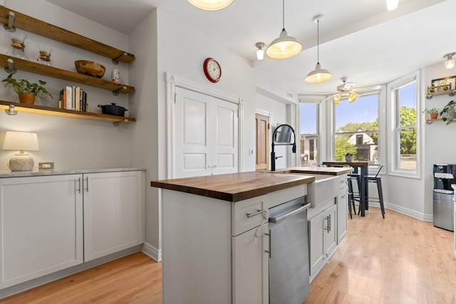 1128 W Wolfram St Unit 2, Chicago, IL 60657 - kitchen featuring butcher block countertops, stainless steel dishwasher, light wood finished floors, decorative light fixtures, and white cabinets