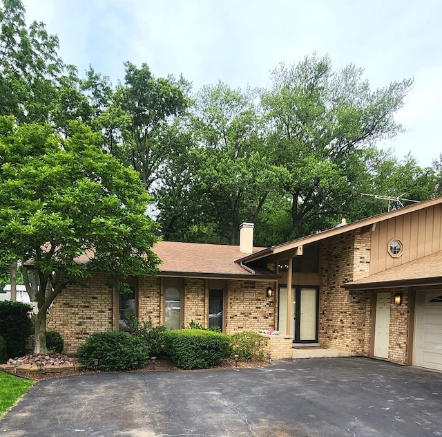 18068 Jason Ln, Lansing, IL 60438 - view of front of house featuring brick siding, asphalt driveway, and a chimney