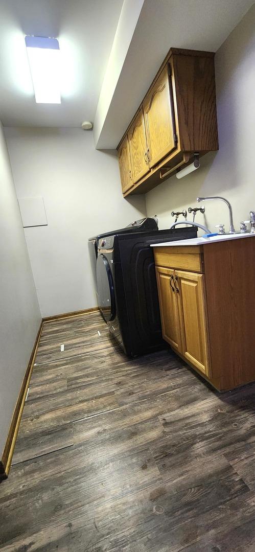18068 Jason Ln, Lansing, IL 60438 - washroom with cabinet space and dark wood-style floors