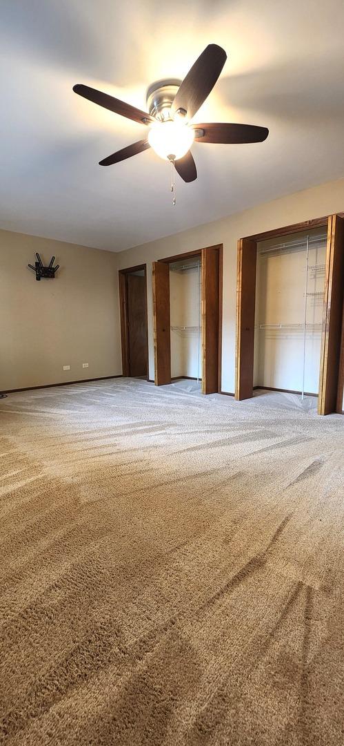 18068 Jason Ln, Lansing, IL 60438 - unfurnished bedroom featuring carpet, two closets, and a ceiling fan