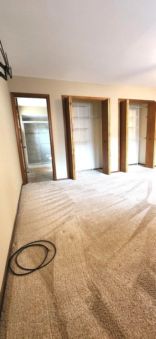 18068 Jason Ln, Lansing, IL 60438 - unfurnished bedroom with carpet flooring and two closets