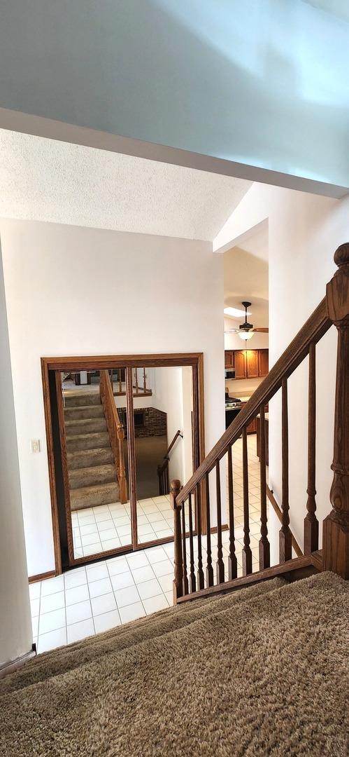 18068 Jason Ln, Lansing, IL 60438 - stairway featuring carpet floors, tile patterned flooring, and a ceiling fan