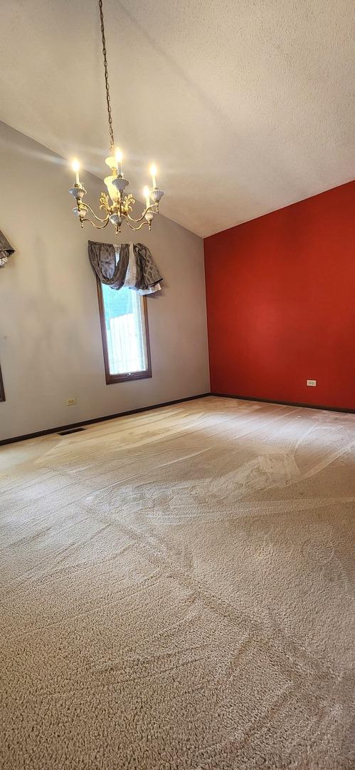18068 Jason Ln, Lansing, IL 60438 - carpeted spare room featuring a chandelier