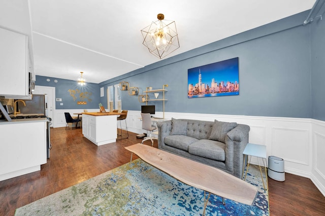 3137 N Monticello Ave, Chicago, IL 60618 - living area featuring dark wood-style floors, wainscoting, and a chandelier