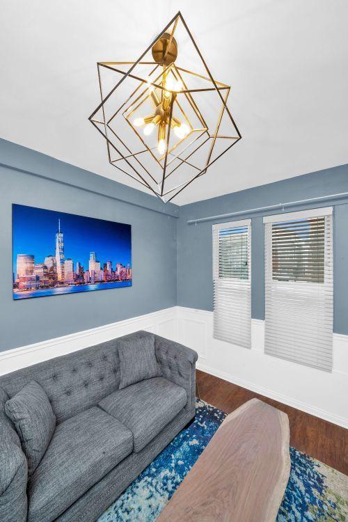 3137 N Monticello Ave, Chicago, IL 60618 - living room featuring a chandelier, wood finished floors, and wainscoting