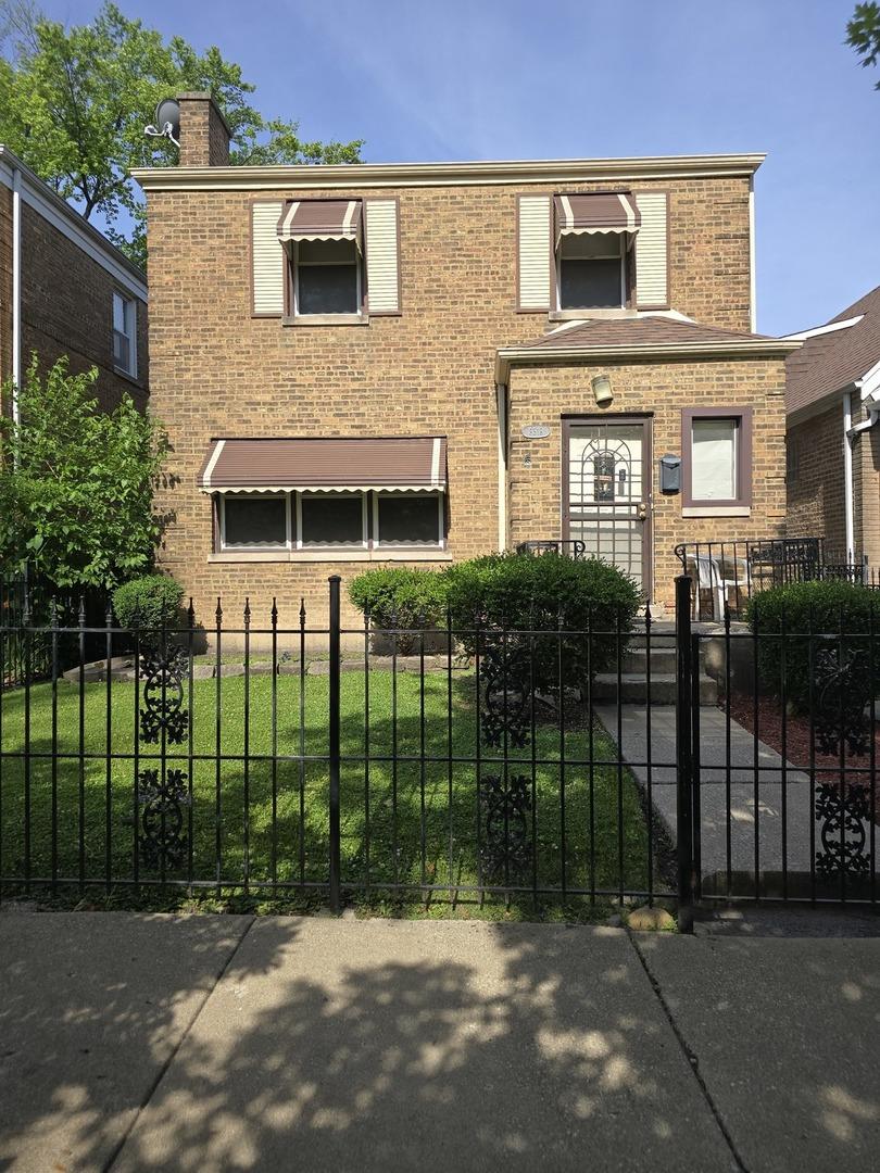 8518 S Seeley Ave, Chicago, IL 60620 - view of front of home featuring brick siding, a fenced front yard, and a chimney