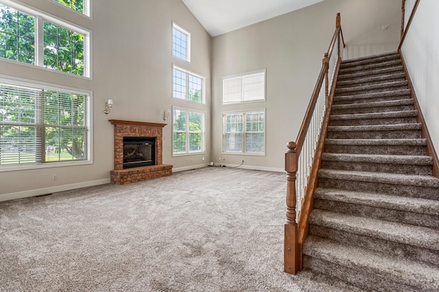 3208 Countrybend Ln, Champaign, IL 61822 - staircase featuring high vaulted ceiling, carpet floors, and a brick fireplace