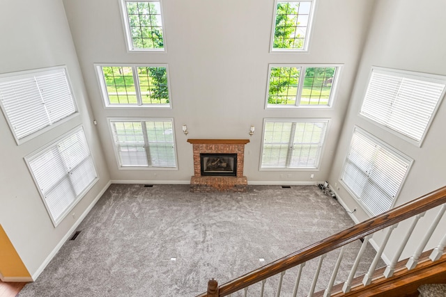 3208 Countrybend Ln, Champaign, IL 61822 - unfurnished living room featuring a towering ceiling, healthy amount of natural light, carpet flooring, a fireplace, and stairway