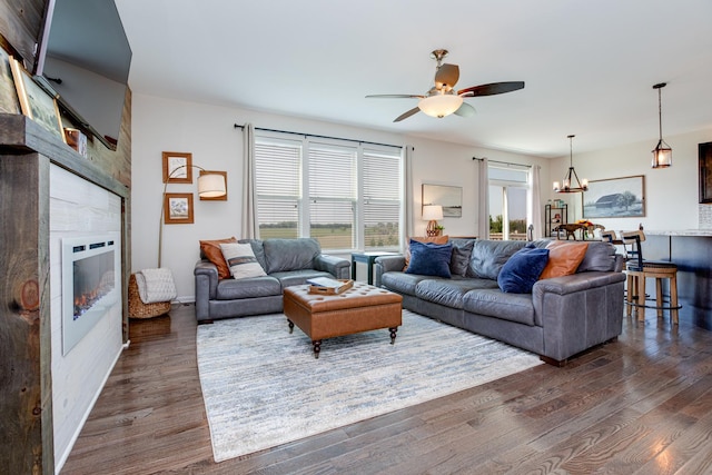 662 Kentshire Dr, Yorkville, IL 60560 - living area featuring a tiled fireplace, dark wood-style floors, ceiling fan, and a chandelier