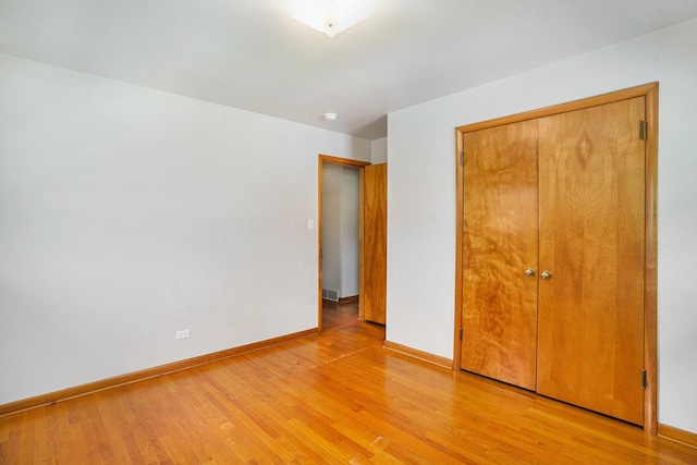 2454 184th St, Lansing, IL 60438 - unfurnished bedroom with light wood finished floors, baseboards, and a closet