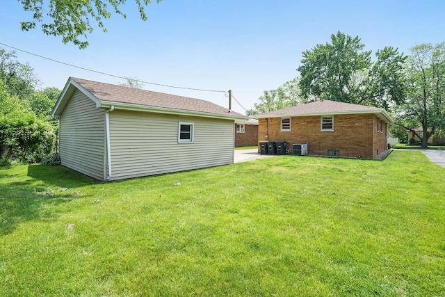 2454 184th St, Lansing, IL 60438 - back of house featuring a lawn, an outdoor structure, brick siding, and central AC unit