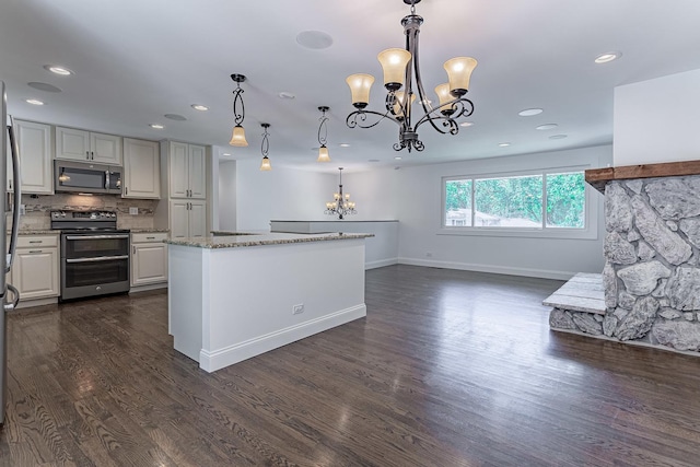 1328 Concord Ln, Schaumburg, IL 60193 - kitchen featuring appliances with stainless steel finishes, a chandelier, light stone counters, dark wood-style flooring, and a kitchen island