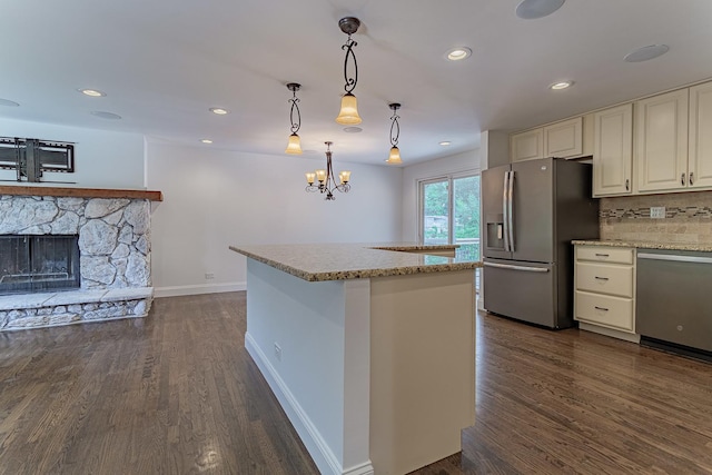 1328 Concord Ln, Schaumburg, IL 60193 - kitchen featuring appliances with stainless steel finishes, dark wood-style flooring, light stone counters, tasteful backsplash, and decorative light fixtures