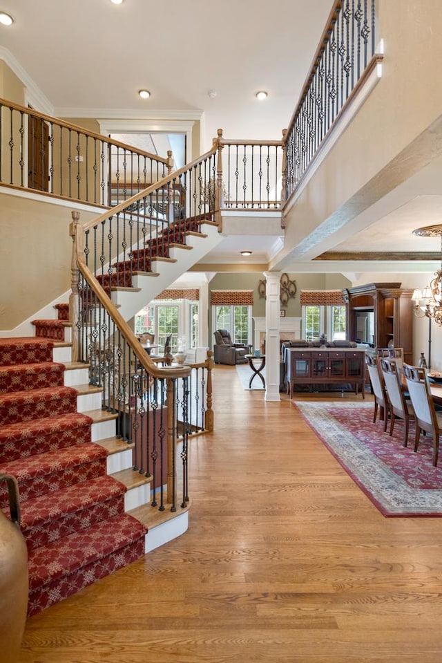 1835 Rizzi Ln, Bartlett, IL 60103 - stairway featuring a towering ceiling, wood finished floors, ornate columns, ornamental molding, and a chandelier