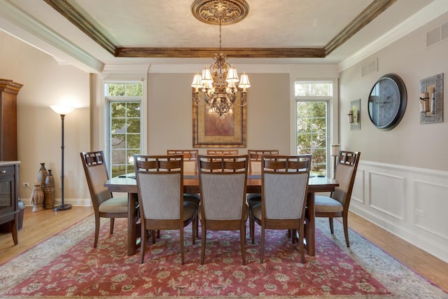 1835 Rizzi Ln, Bartlett, IL 60103 - dining space with wood finished floors, plenty of natural light, a chandelier, a raised ceiling, and crown molding