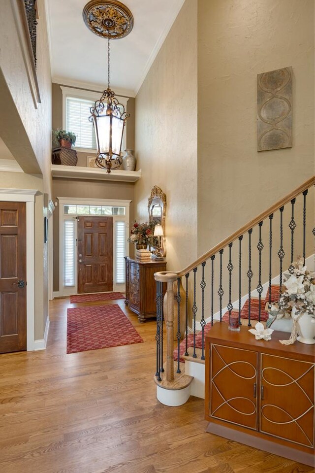 1835 Rizzi Ln, Bartlett, IL 60103 - entryway featuring a chandelier, crown molding, wood finished floors, a towering ceiling, and stairway