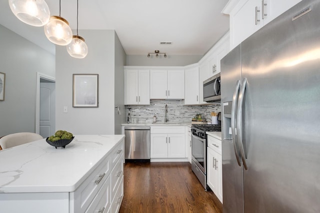 3437 S Morgan St Unit 2E, Chicago, IL 60608 - kitchen with appliances with stainless steel finishes, a sink, dark wood-type flooring, tasteful backsplash, and white cabinets