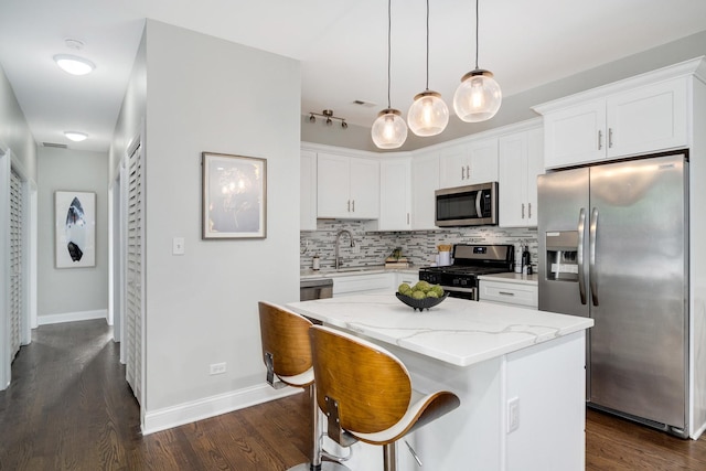 3437 S Morgan St Unit 2E, Chicago, IL 60608 - kitchen featuring appliances with stainless steel finishes, backsplash, dark wood finished floors, light stone counters, and white cabinets