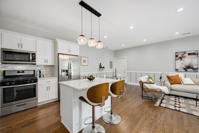 3437 S Morgan St Unit 2E, Chicago, IL 60608 - kitchen with stainless steel appliances, dark wood-style flooring, white cabinetry, wainscoting, and open floor plan