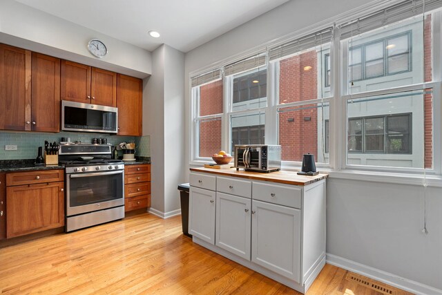 5844 N Hermitage Ave Unit B, Chicago, IL 60660 - kitchen with stainless steel appliances, decorative backsplash, light wood finished floors, brown cabinets, and recessed lighting