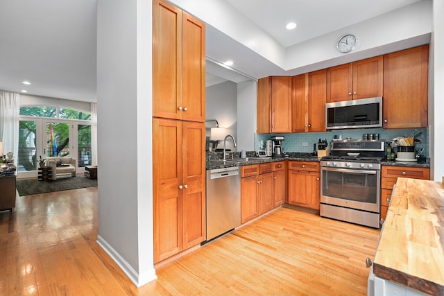 5844 N Hermitage Ave Unit B, Chicago, IL 60660 - kitchen featuring stainless steel appliances, light wood-style floors, butcher block counters, backsplash, and french doors